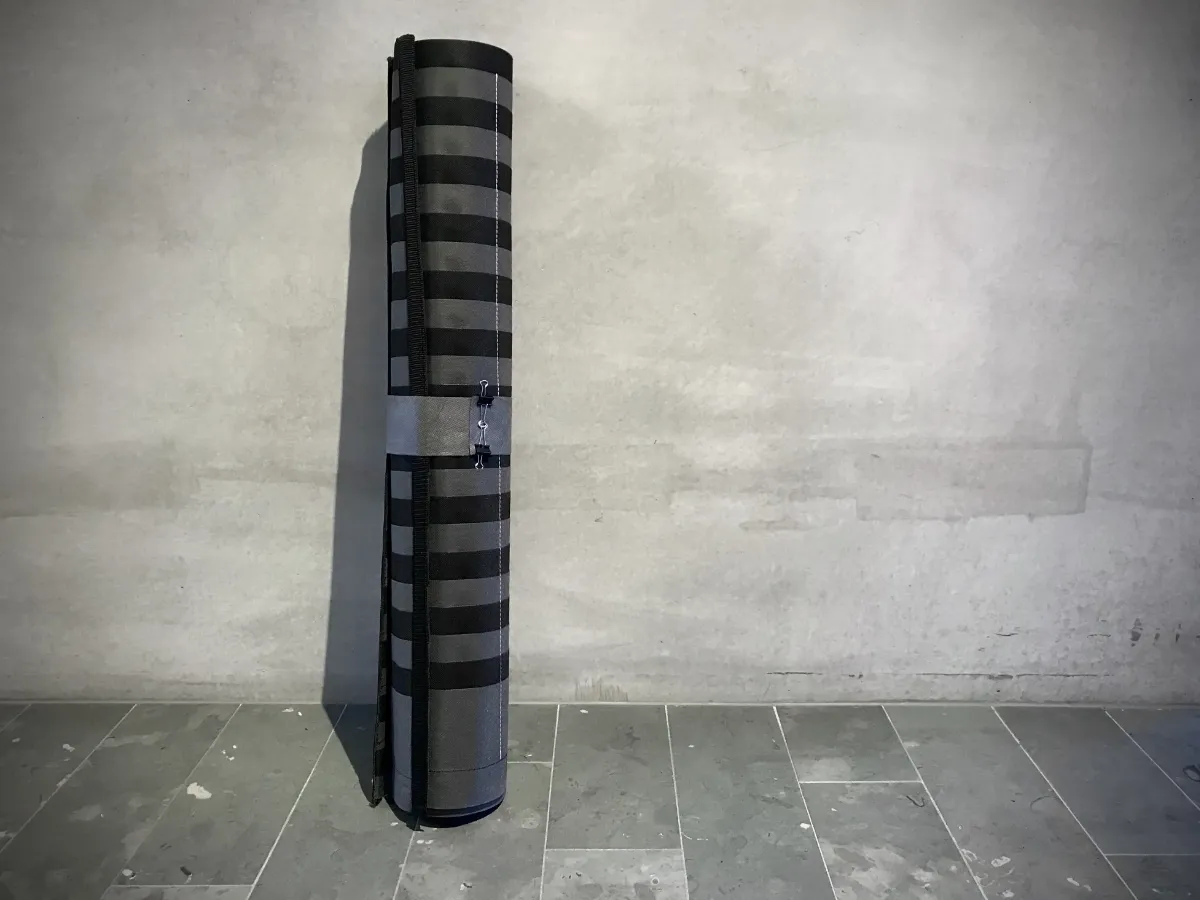 Zusammengerollte, transportable Lean Construction Stecktafel aus grauem Vlies – platzsparende Lösung für die Baustelle.