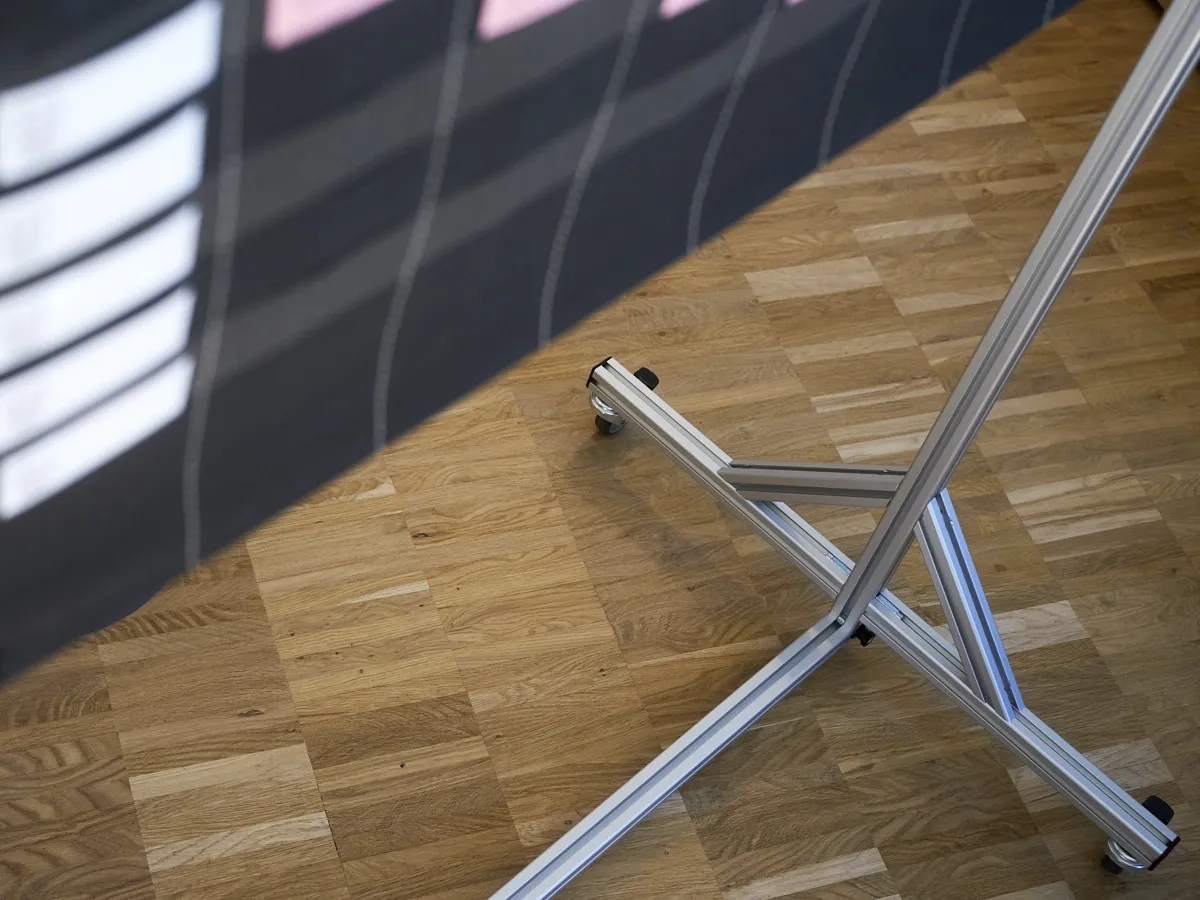 Stabile Standfüße mit Rollen am Aluminiumprofil-Gestell für maximale Mobilität der Planungswand in Besprechungsräumen.